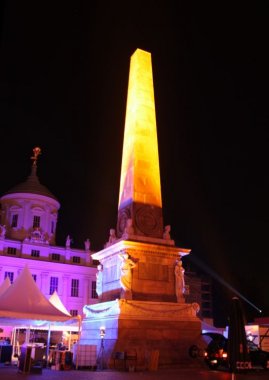 der Obelisk auf dem Alten Markt illuminiert, im Hintergrund das Rathaus